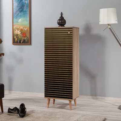A tall, slatted shoe cabinet with a decorative lantern on top, placed in a room with a painting on the wall and a floor lamp.