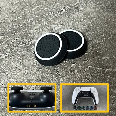 Two black and white thumbstick grips for a game controller are shown on a textured gray surface. Two smaller inset images show the bottom of a game controller and a white game controller with colored thumbstick grips.