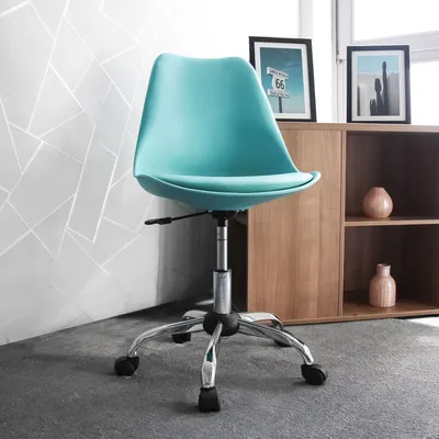 A turquoise office chair is shown in a room with a patterned wall and a wooden cabinet.