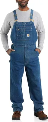 A man wearing denim overalls and a long-sleeved shirt.