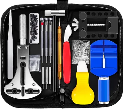 A flat lay of a watch repair tool kit laid out inside a black zippered case.