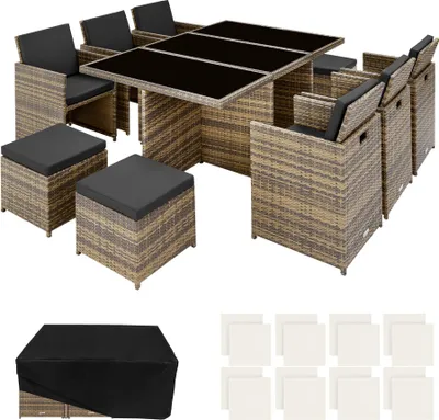 An outdoor rattan dining set with chairs, ottomans, and a table, along with a protective cover and cushions.