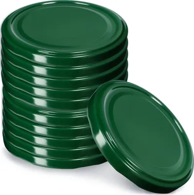 A stack of green metal jar lids with one lid placed in front of the stack.