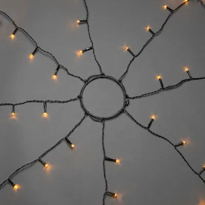 Produktbild von Konstsmide LED Baummantel mit Ring, 8 Stränge à 70 Dioden, vormontiert, mit Glimmereffekt, 560 bernsteinfarbene Dioden (280 glimmend), 24V Außentrafo, schwarzes Kabel - 6322-810