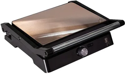 A close-up, angled view of a black electric grill toaster with a bronze-colored lid.