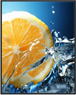 Produktbild von Wallario Wandbild Orange in spritzigem Wasser vor blauem Hintergrund, Größe: 40,30 x 50,30 cm, Poster mit schwarzem Aluminiumrahmen