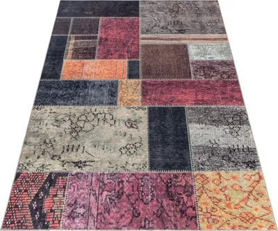 A patchwork rug is shown from a diagonal angle on a white background.