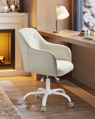 A cream-colored, textured office chair is shown in a cozy room with a fireplace and a window.