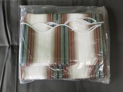 A product packaged in plastic, showing striped fabric.