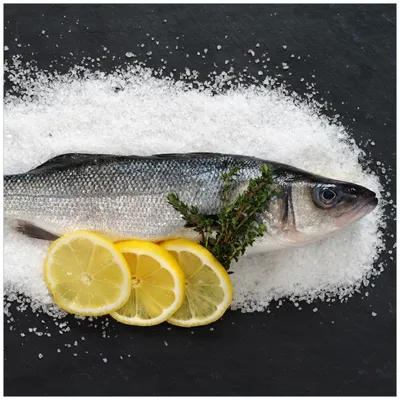 Produktbild von Wallario Sticker / Aufkleber für Kühlschrank / Geschirrspüler / Küchenschränke, selbstklebende Folie - 60 x 60 cm, Motiv: Fischmenü - Frischer Fisch auf Salz mit Zitronen