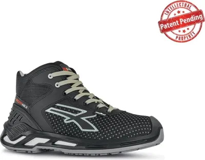 A black high-top safety shoe with a white sole and grey accents, set against a white background. A red circular stamp with text is in the top right corner.