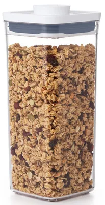 A clear, well-lit studio shot of a clear plastic food storage container filled with granola.
