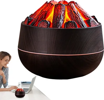 A woman is working at a desk with a laptop and a small humidifier with a flame effect.