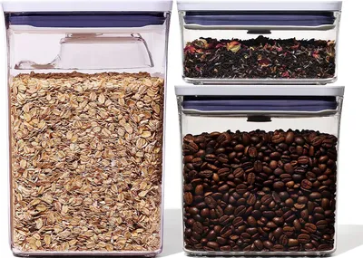 Three clear storage containers filled with oats, tea, and coffee beans, arranged on a white background.