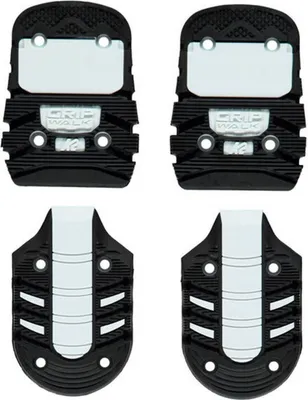 Four ski boot soles are arranged in a two-by-two grid against a white background.