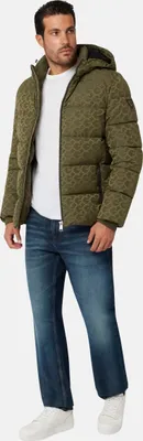 A man wearing a green puffer jacket and blue jeans, posing for a product shot.