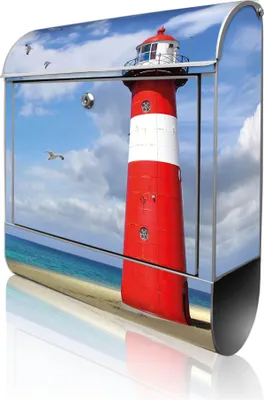 A mailbox with a lighthouse design on a beach.