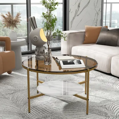 A modern living room scene featuring a round coffee table with two shelves, a sofa, and a decorative lamp.