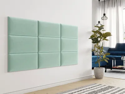 A wall decorated with mint green upholstered panels in a modern living room setting.