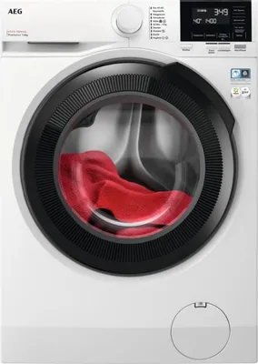 A front view of a white washing machine with a black door and a red towel inside.