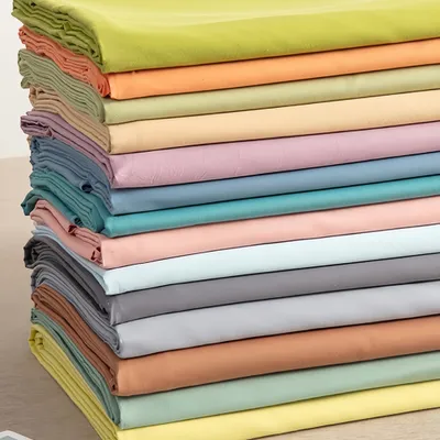 A stack of folded fabric sheets in various pastel colors.