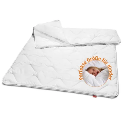 A white children's duvet is laid out diagonally on a white background. A circular graphic with a smiling child and German text is overlaid on the duvet.