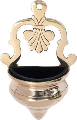 A brass holy water font with a fleur-de-lis design.