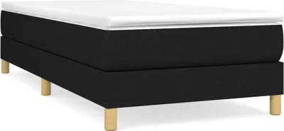 A black bed frame with a white mattress topper, shown from a side angle with wooden legs.