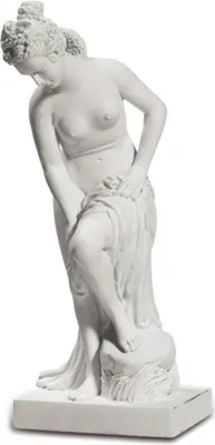 A white marble statue of a woman, possibly Venus, in a bathing pose.