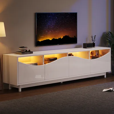 A modern white TV stand with LED lighting, featuring a television displaying a starry night sky.