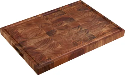 A wooden cutting board with a textured surface and a grooved edge.