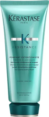 A product shot of a teal colored tube of Kerastase hair conditioner.