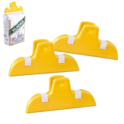 Three yellow bag clips are arranged on a white background, with a bag of flour in the upper left corner.