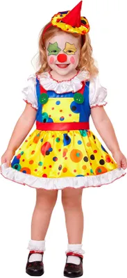 A young child dressed in a colorful clown costume, standing against a white background.