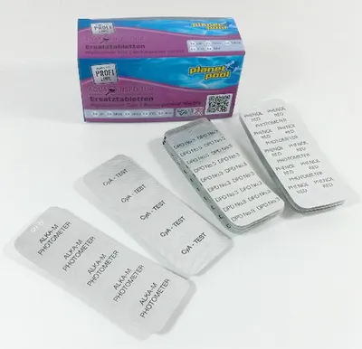 A box of test tablets for pool water testing is shown with several individual test strips laid out in front of it.