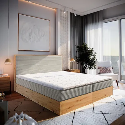 A bedroom scene with a large bed, artwork on the wall, and a window overlooking the sea.