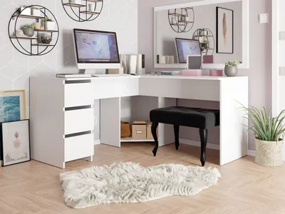 A white L-shaped desk with a computer, books, and decorative items, set in a room with patterned wallpaper and wooden flooring.
