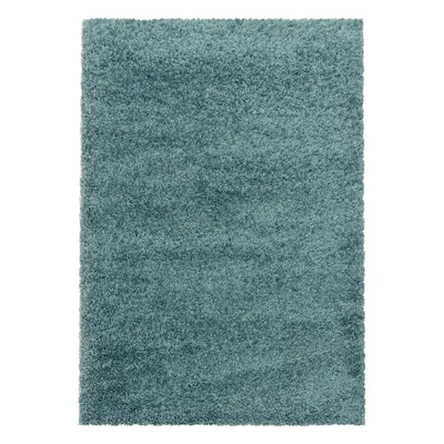 A rectangular shaggy rug in a teal color.