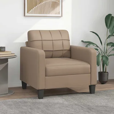 A cappuccino-brown armchair is shown in a room setting with a plant and a side table.