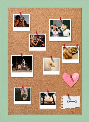 A cork board with several photos and a heart-shaped cutout pinned to it.