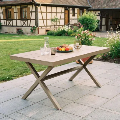 A table set with fruit and bread on a patio in front of a house.