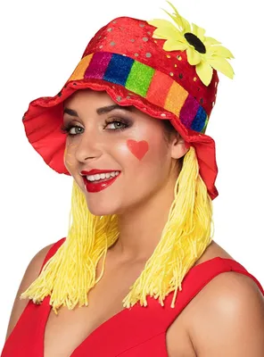 A woman wearing a clown hat with attached yellow yarn hair.