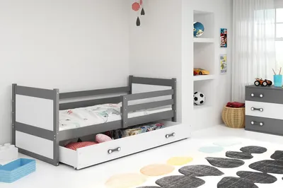 A child's bed with storage drawers in a room setting.