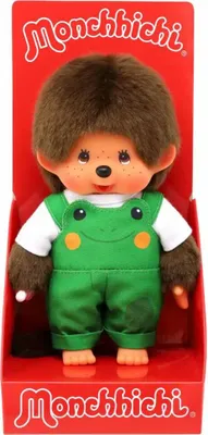 A Monchhichi doll wearing a frog-themed outfit, presented in its retail packaging.