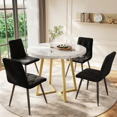 A dining set with a round marble-top table and four black velvet chairs in a well-lit room.