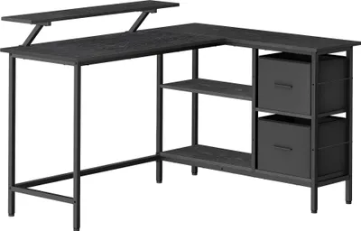 A black L-shaped desk with shelves and drawers, shown from a slightly elevated side angle against a white background.