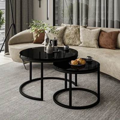 A modern living room scene with a curved sofa, decorative pillows, and two round coffee tables.