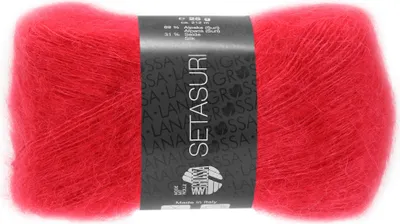 A ball of red yarn with a black label wrapped around it.