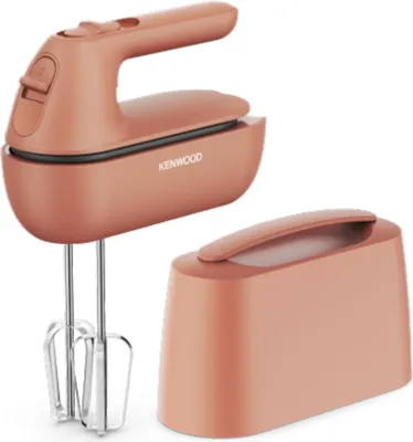 A coral-colored Kenwood hand mixer and its storage base are displayed against a white background.