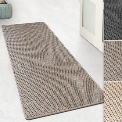 A taupe runner rug with a sisal-like texture is laid out on a light-colored floor, with a partially open white door in the background. There are also smaller inset images showing different color variations of the rug.